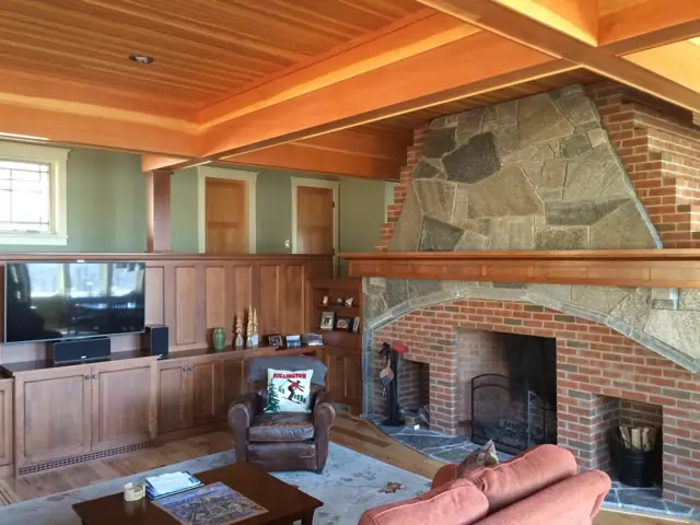 Living area with a large stone fireplace and wood-paneled ceiling