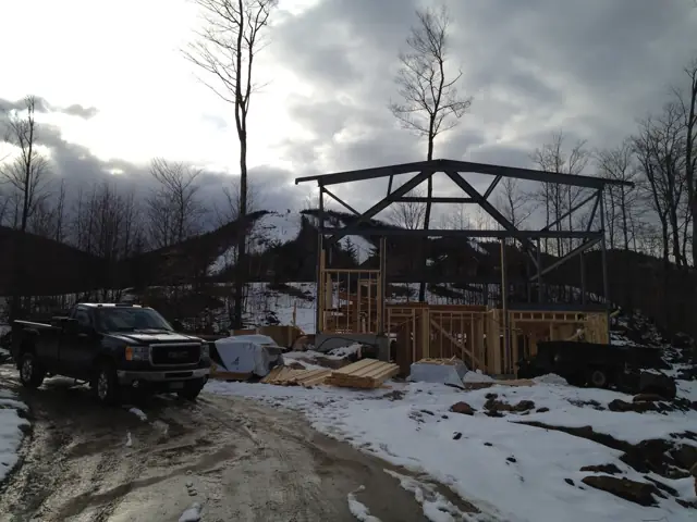 Timber frame rising on a snowy mountain site