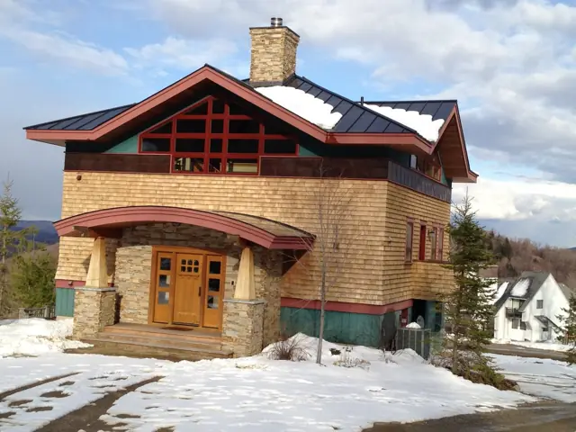 Stucco and stone home with red-trimmed gables