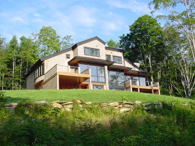 Contemporary home with balconies over a green hillside