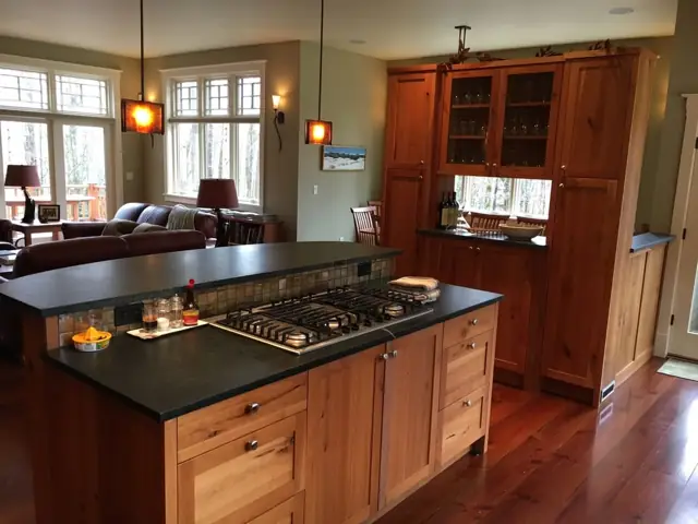 Kitchen with cherry cabinetry, island and pendant lights