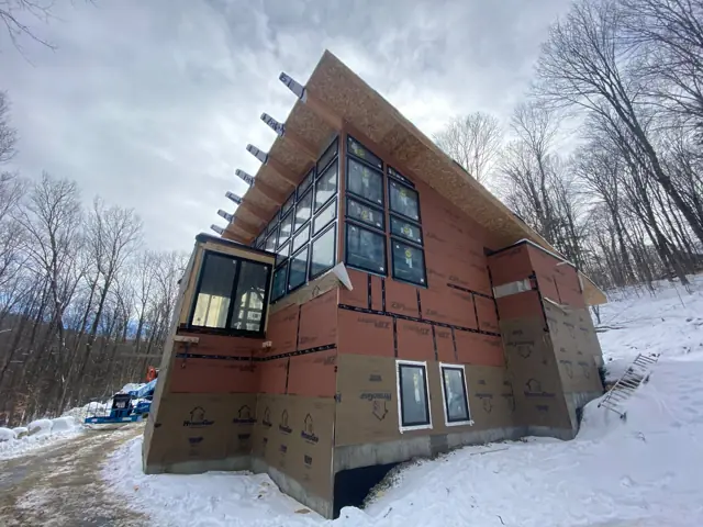 Angular modern home with tall windows in snow